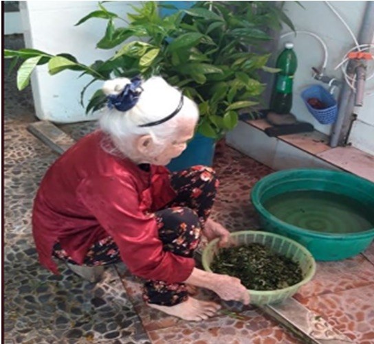 Cụ Nguyễn Thị Huệ đang làm hến, chuẩn bị bữa trưa cho gia đình. (Ảnh: SQH)