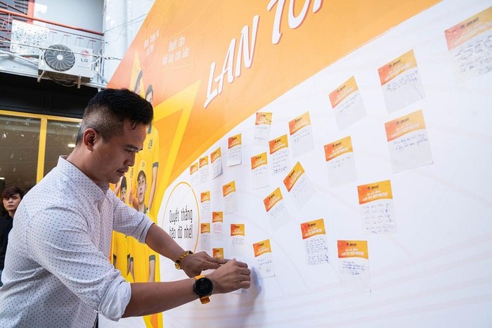 Khách hàng viết lời chia sẻ ủng hộ đồng bào miền Trung trong ngày ra mắt quán cà phê flagship Ông Bầu đầu tiên.