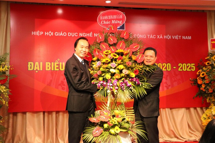 Thứ trưởng Bộ Lao động - Thương binh và Xã hội Lê Văn Thanh (bên phải) tặng lẵng hoa chúc mừng Đại hội Đại biểu lần thứ III của Hiệp hội Giáo dục nghề nghiệp và nghề công tác xã hội Việt Nam