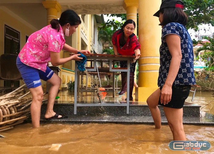 Nước chưa kịp rút, các cô lại bắt tay dọn dẹp nhà trường để đón học sinh. Ảnh tư liệu: AN