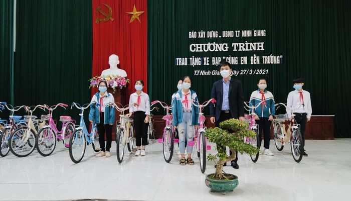 Lãnh đạo Báo Xây dựng trao tặng xe đạp cho các em học sinh.