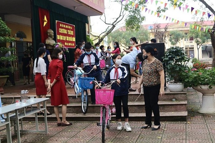 Các em học sinh vui mừng khi có xe đạp mới tới trường.