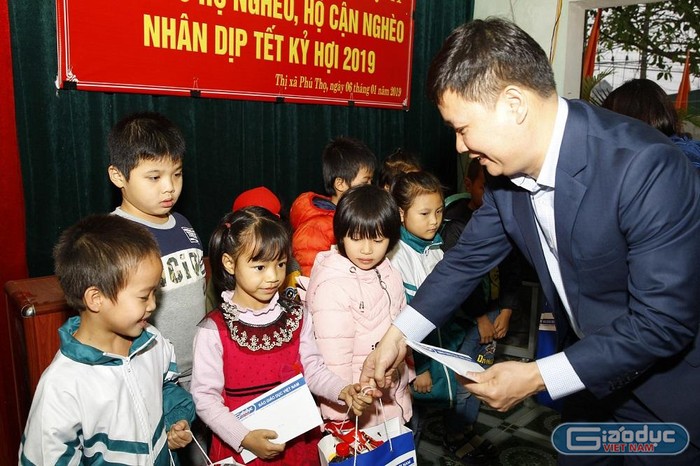 Nhà báo Nguyễn Tiến Bình tặng quà Tết cho các học sinh có hoàn cảnh khó khăn. Ảnh: Tùng Dương