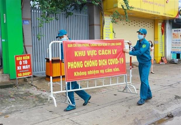 Lực lượng chức năng thực hiện dỡ bỏ phong tỏa cho 20 hộ dân tại khu phố 2, phường Xuân Thanh, thành phố Long Khánh, Đồng Nai. (Ảnh: Lê Xuân/TTXVN)