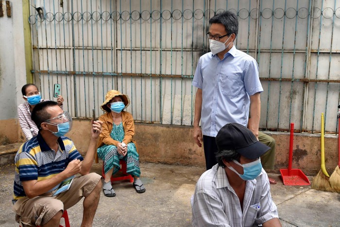 Phó Thủ tướng trò chuyện với người dân tại điểm tiêm vaccine phòng COVID-19 ở Trường Tiểu học Bạch Đằng (Quận 4). Ảnh: VGP/Đình Nam