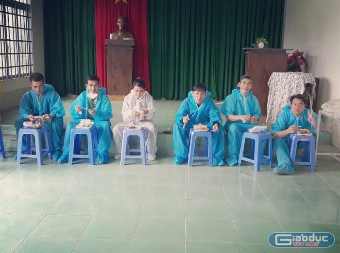 Cô giáo Trần Thị Thư (mặc bảo hộ màu trắng) cùng với đồng đội ăn vội bữa trưa để tiếp tục nhiệm vụ. Ảnh: Nhân vật cung cấp