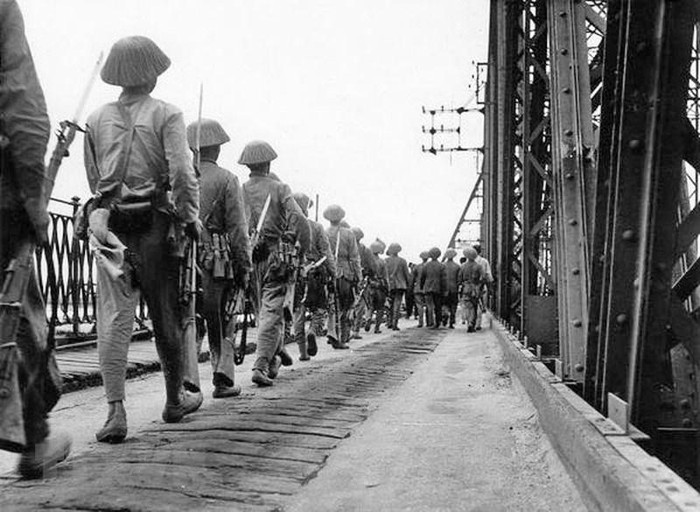 Bộ đội ta hùng dũng tiến qua cầu Long Biên vào tiếp quản Hà Nội, cùng lúc quân Pháp rút khỏi Hà Nội qua cây cầu này phía chiều bên kia, chiều 9/10/1954. (Ảnh: Tư liệu TTXVN)