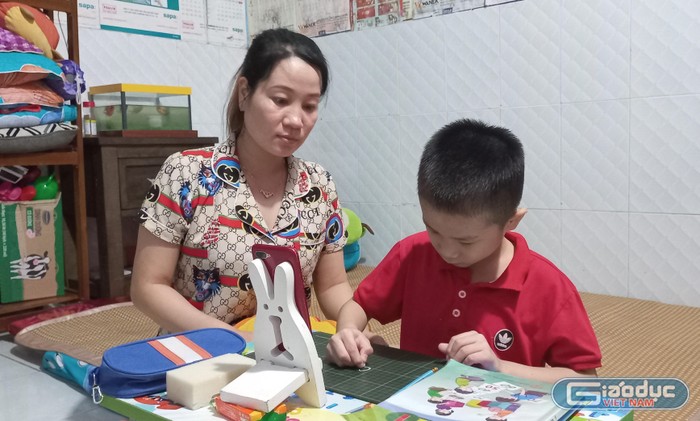Chị Nguyễn Thị Đẹt đang hỗ trợ con trai học online tại phòng trọ. Ảnh: Hữu Đức