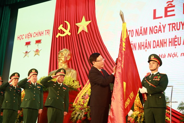 Phó Thủ tướng Thường trực Phạm Bình Minh gắn Huy hiệu Anh hùng LLVT lên quân kỳ Học viện Chính trị. Ảnh: VGP/Hải Minh