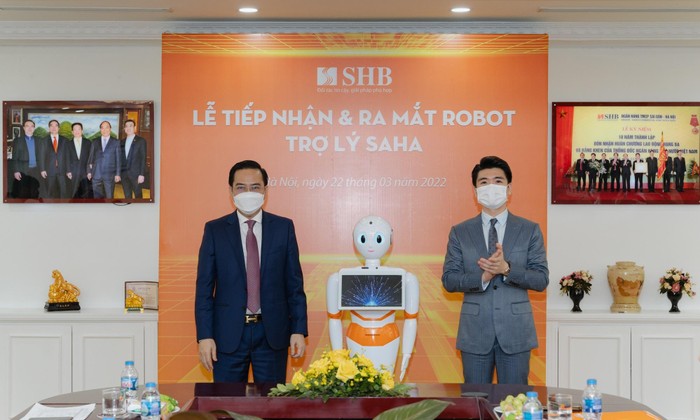 Ông Đỗ Quang Vinh – Phó Tổng Giám đốc SHB (bên phải) cùng ông Trần Mạnh Hà – Phó Tổng Giám đốc AIC Group chào mừng Robot Trợ lý SAHA chính thức gia nhập đại gia đình SHB