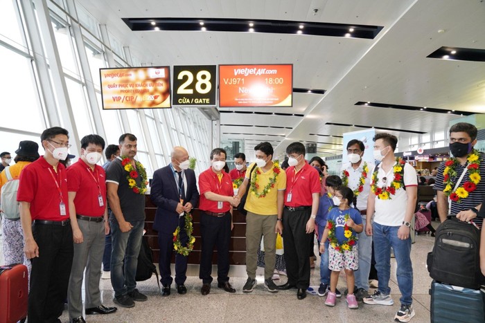 Phó Cục trưởng Cục Hàng không Việt Nam Hồ Minh Tấn (áo vest xanh) và Phó Tổng giám đốc Vietjet Nguyễn Đức Thịnh (áo đỏ) tặng hoa chào mừng những hành khách đầu tiên trên chuyến bay thẳng kết nối hai thủ đô Hà Nội và New Delhi (Ấn Độ)