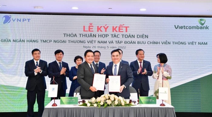 Ông Nguyễn Thanh Tùng - Phó Tổng Giám đốc Phụ trách Ban Điều hành Vietcombank (bên phải) và ông Huỳnh Quang Liêm - Tổng Giám đốc VNPT thực hiện nghi thức ký Thỏa thuận hợp tác toàn diện dưới sự chứng kiến của lãnh đạo 2 bên