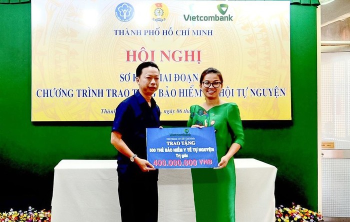 Bà Lê Thị Hòa Bình - Phó Giám đốc Vietcombank Thành phố Hồ Chí Minh (bên phải) trao tặng 500 thẻ Bảo hiểm y tế cho đại diện Liên đoàn Lao động Thành phố Hồ Chí Minh để phân bổ đến những hoàn cảnh đoàn viên khó khăn