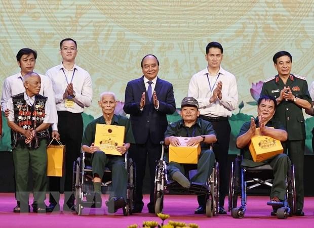 Chủ tịch nước Nguyễn Xuân Phúc và Đại tướng, Bộ trưởng Quốc phòng Phan Văn Giang trao quà cho người có công và các thương bệnh binh. (Ảnh: Thống Nhất/TTXVN)