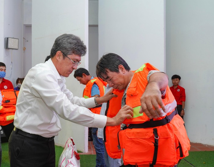 Ông Nguyễn Minh - Tỉnh ủy viên, Phó Chủ tịch Uỷ ban nhân dân tỉnh Bình Thuận trao áo phao cho ngư dân nghèo