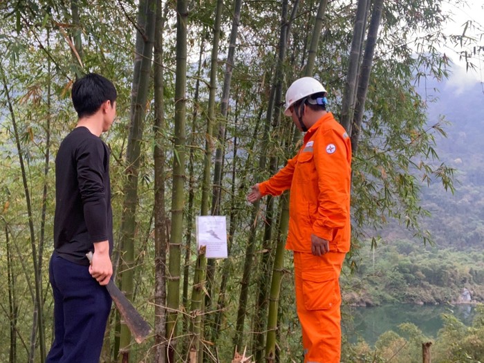 Công nhân Điện lực trực thuộc Công ty Điện lực Thanh Hóa tuyên truyền đến người dân về việc chặt tỉa cây trồng nằm trong phạm vi có nguy cơ gây mất an toàn hành lang lưới điện.