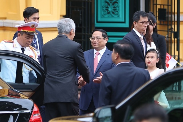 Thủ tướng Phạm Minh Chính đón Thủ tướng Singapore Lý Hiển Long tại xe. Ảnh: VGP/Nhật Bắc