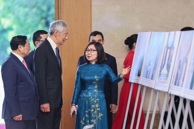 Thủ tướng Phạm Minh Chính và Thủ tướng Singapore Lý Hiển Long xem trưng bày ảnh về quan hệ hợp tác giữa Việt Nam và Singapore. Ảnh: VGP/Nhật Bắc