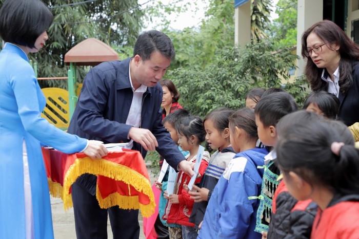Tổng Giám đốc Bảo hiểm xã hội Việt Nam Nguyễn Thế Mạnh tặng thẻ bảo hiểm y tế cho học sinh tại tỉnh Điện Biên.
