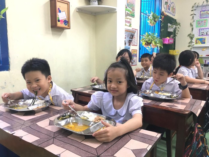 Các em học sinh tiểu học trong giờ ăn trưa với thực đơn từ Dự án Bữa ăn học đường.