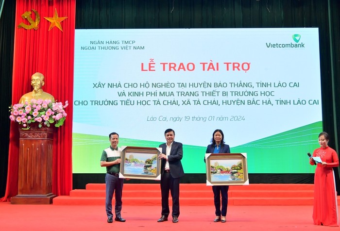 Ông Lê Hoàng Tùng - Phó Tổng Giám đốc Vietcombank trao quà lưu niệm Ban lãnh đạo Vietcombank tặng lãnh đạo huyện Bảo Thắng (ở giữa) và huyện Bắc Hà (ngoài cùng bên phải).