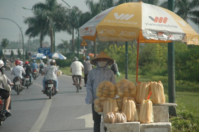 Bác bán bánh mì đứng đợi người qua đường (ảnh Viết Cường)