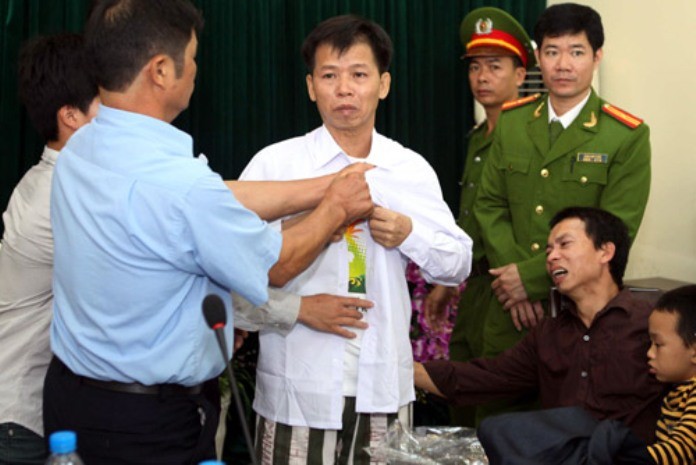 Ông Chấn đang cởi bỏ chiếc áo tù nhân, mặc chiếc áo thường dân sau hơn 10 năm ngồi tù vì án chung thân