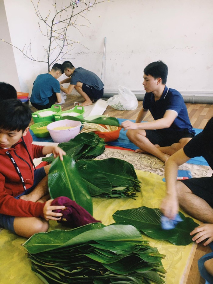 Nhóm du học sinh phân công việc chuẩn bị gói bánh chưng, làm cây đào Tết. Ảnh: Bùi Thị Thanh Hà
