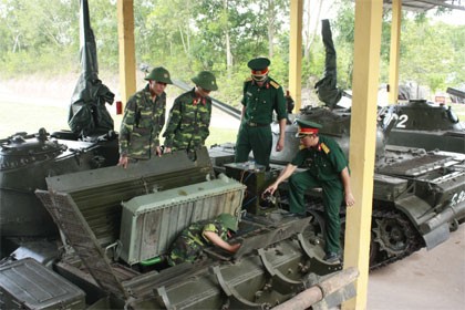 Trung tá Phạm Phú Liên (ngoài cùng bên phải) hướng dẫn bảo dưỡng, sửa chữa xe tăng tại đơn vị.