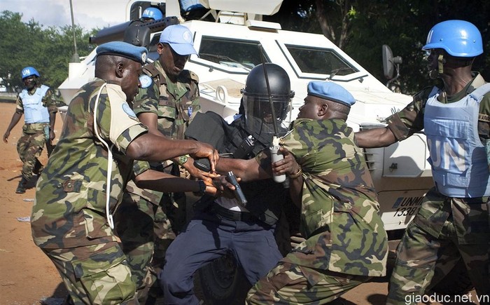 Lính gìn giữ hoàn bình Nigeria đang khống chế một cảnh sát chống bạo động người bản địa (Liberia) khi anh này bắn 5 phát súng trước toà nhà hành chính ở Monrovia.