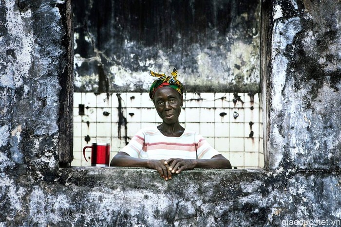 Một phụ nữ Liberi đang đứng gần cửa sổ nhìn ra ngoài từ một căn nhà bỏ hoang ở Monrovia, Liberia.