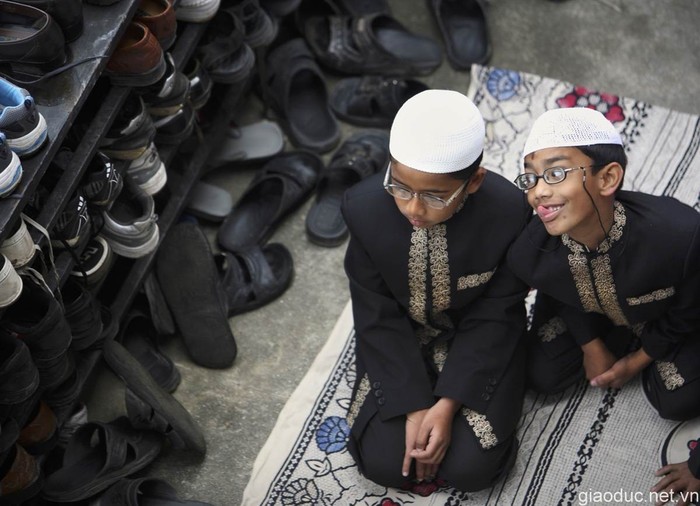 Một tín đồ Hồi giáo nhỏ tuổi ở Kathmandu, Nepal đang trêu đùa người cùng ngồi cạnh trong khi hành lễ.