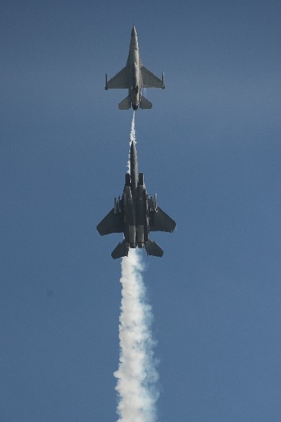 Chiếc F-16C (trên) và F-15SG (dưới) của Không quân Singapore thực hiện một màn bay nối đuôi thẳng đứng.
