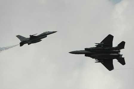 Chiếc F-16C (trái) bay chậm lại trong khi chiếc F-15SG "nghiêng cánh" bay với tốc độ cao hơn để thực hiện một màn bay xuyên ngược chiều.
