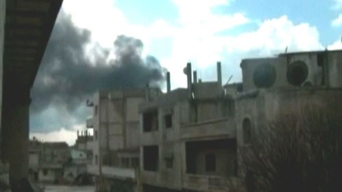 Khói bốc lên từ thành phố Homs - Ảnh: Reuters