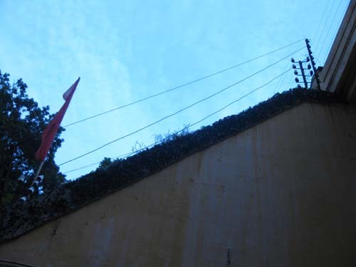 Trên các bức tường rào được gia cố bởi hệ thống dây thép gai có dòng điện cao thế chạy qua