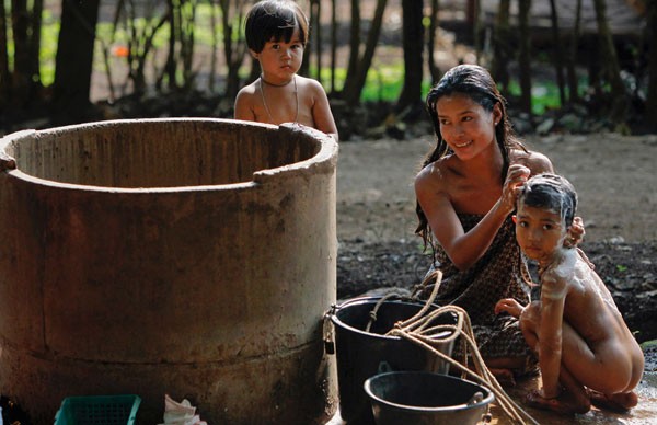Người đàn bà dân tộc thiểu số Mon tại làng Ban Bor Yeepun đang tắm cho lũ con của mình.