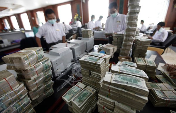 Những người thủ quỹ của một ngân hàng tư nhân ở Yangon hôm 21/7/2011. Ngân hàng trung ương Myanmar đặt mức tỷ giá cố định của đồng Kyat là 1 USD = 820 Kyat, gần bằng với tỷ giá của thị trường tự do. Đây là một trong những động thái nhằm cải cách kinh tế của chính quyền nước này.