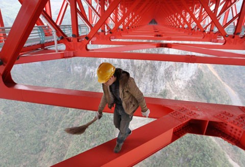 Một công nhân làm vệ sinh trên thân cầu ở độ cao hơn 350 m. Ảnh: Ifeng