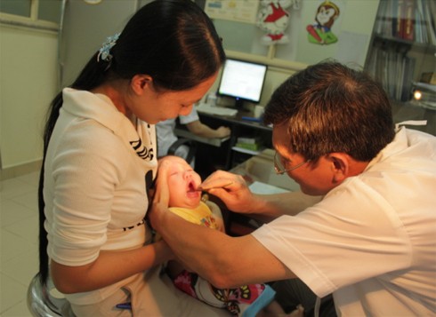 Bác sĩ Cấn Phú Nhuận khám cho một em bé ở Bắc Ninh nghi bị tay chân miệng. Ông cho biết, gần đây, nhiều bố mẹ đưa con tới khám vì lo sợ bệnh này, nhưng con số mắc thật sự rất ít. Xem thêm: Những loại quả cực tốt cho sức khỏe / Cách phòng bệnh cho bé.