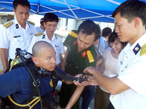 Các thợ lặn bắt đầu mang trang thiết bị và được các bác sĩ hải quân Việt Nam hỏi rất kỹ