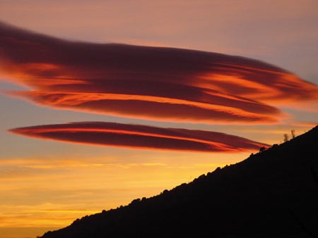 Những đám mây hình thấu kính phía trên dãy núi Alpujarra ở phía nam Tây Ban Nha. Ánh sáng mặt trời khiến chúng có màu đỏ. Người ta thường lầm tưởng chúng là đĩa bay. Ảnh: Richard Hamblyn.