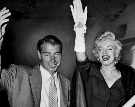 Cặp vợ chồng mới cưới Joe DiMaggio và Marilyn Monroe vẫy chào người hâm mộ tại sân bay quốc tế Idlewild.