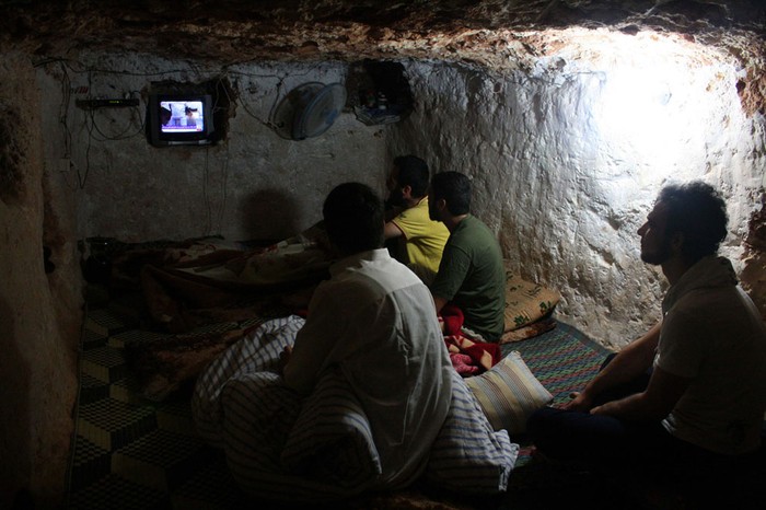 Người dân Syria xem TV dưới hầm ở Al-Bueda, Homs hôm 24/7/2012