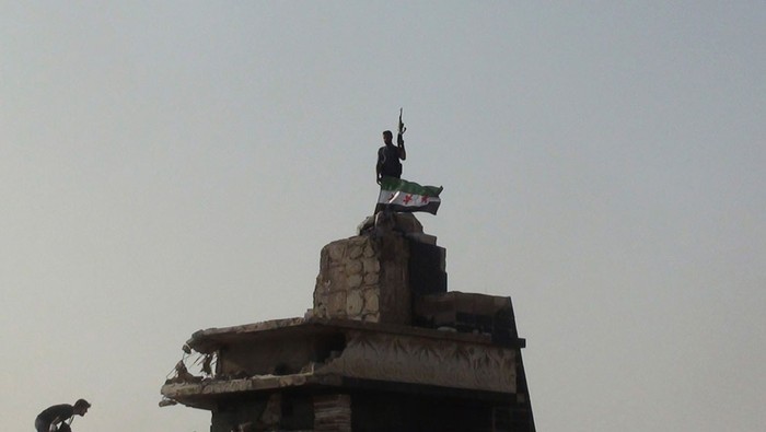 Một binh sỹ thuộc lực lượng nổi dậy đang cầm cây súng trường đứng trên nóc một ngôi nhà đổ nát ở Al-Rasten, gần thành phố Homs hôm 27/7.