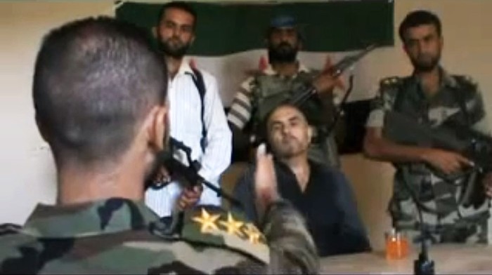 Một phi công quân chính phủ tên Rafik Mohammed Suleiman đang bị các tay súng nổi dậy thẩm vẫn ở Deir el-Zour ngày 13/8/2012.