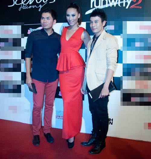 Huyền Trang diện chiếc đầm cut-out màu đỏ sang trọng, bên phải là nhà thiết kế Trương Thành Long.