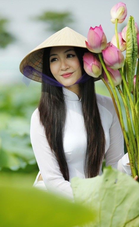 Á hậu Thùy Trang đẹp dịu dàng bên hoa sen và tà áo dài truyền thống.