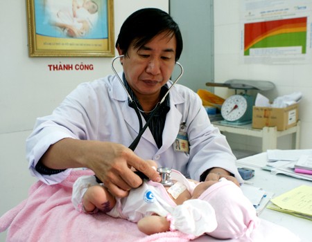 Tiến sĩ - bác sĩ Ngô Minh Xuân đang chăm sóc cho một em bé sơ sinh. Ảnh: Thiên Chương