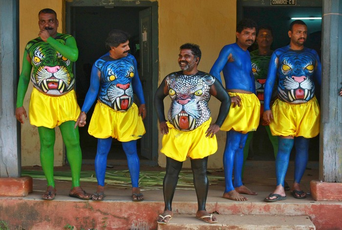 Các vũ công với thân thể được vẽ hình Cọp-Báo chuẩn bị tham gia và một màn trình diễn ở lễ hội “Onam” được tổ chức thường niên để bắt đầu mùa thu hoạch ở Kochi, Ấn Độ, 21/08/2012.